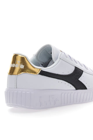 Bele superge z črnim in zlatim logotipom DIADORA GAME STEP SKIN GS