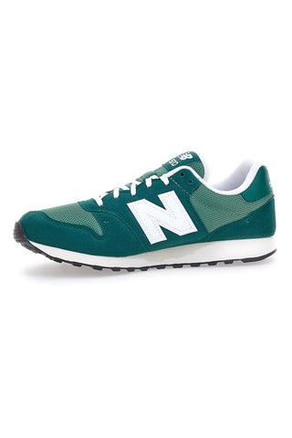 Zelene superge z logotipom New Balance 500 na strani